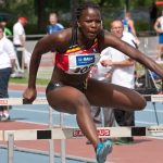 woman jumping over hurdle